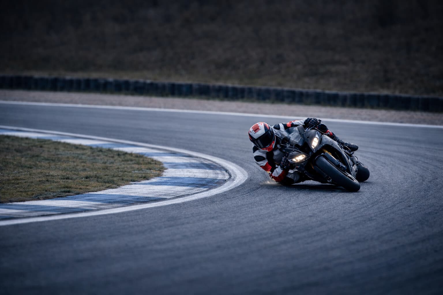 Racer dragging a knee through a corner at full lean