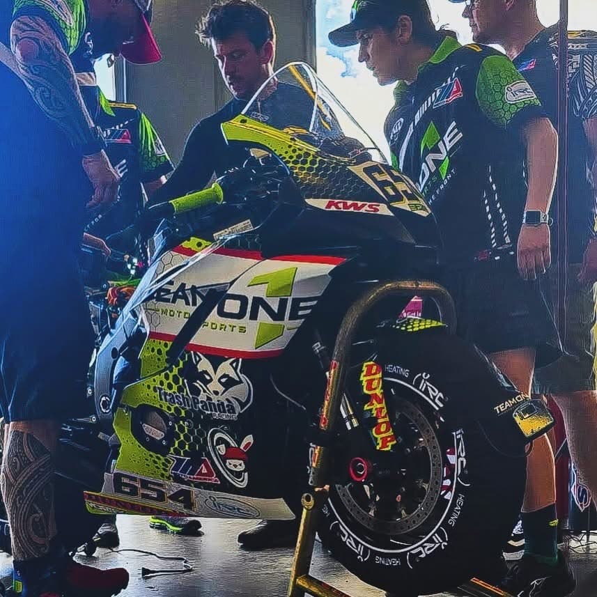 Team One Motorsports race bike #654 on IRC Components tire warmers in the pit with the crew